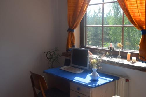 a desk with a computer on it with a window at Chatka skrzatka in Kruki