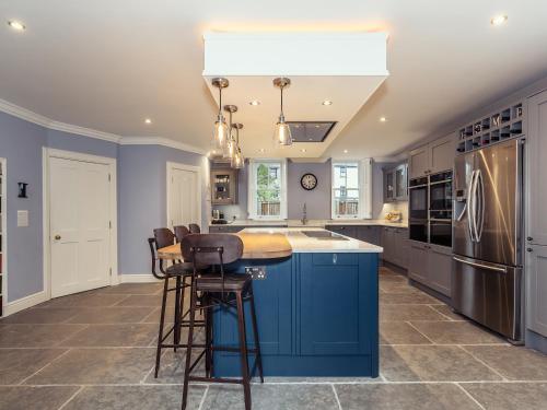 a kitchen with blue cabinets and a blue island at Vallis Oak Villa in Frome