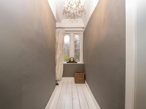 a hallway with a chandelier and a window at Vallis Oak Villa in Frome