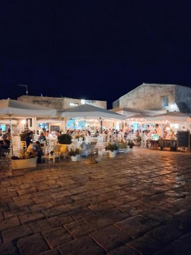 un marché en plein air avec des parasols blancs la nuit dans l'établissement Aloha Marzamemi Rooms, à Marzamemi