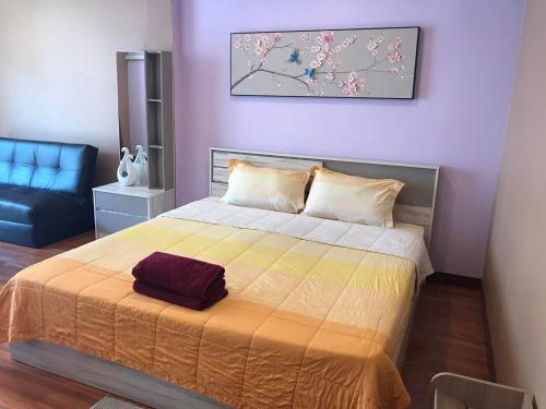 a bedroom with a bed and a black chair at Concordia Guesthouse in Jomtien Beach