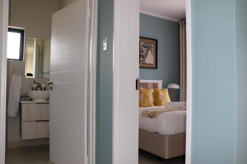 a bedroom with a bed and a bathroom at The Gold Portrait @ Carlswald in Midrand