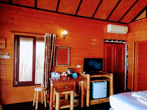 1 dormitorio con escritorio, TV y cama en Bow Thong Beach Resort en Ko Tao