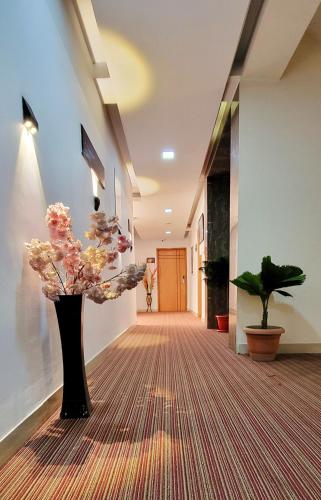 a hallway with a vase of flowers on a carpet at White Palace Hotel in Dhaka