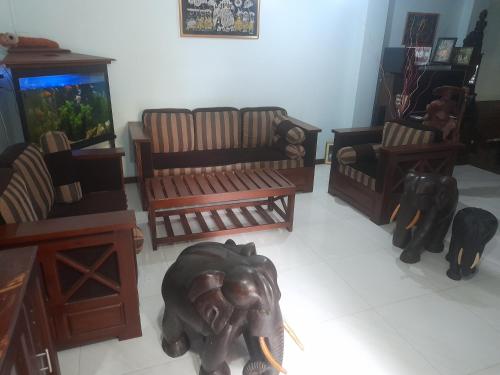 una sala de estar con muebles y un elefante en el suelo en Chari Eco Bungalow, en Matara