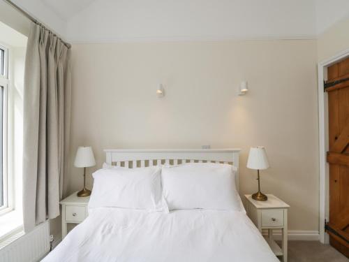 a bedroom with a white bed with two lamps on tables at 2 Church Street in Chipping Norton