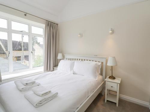 Schlafzimmer mit einem weißen Bett und einem Fenster in der Unterkunft 2 Church Street in Chipping Norton