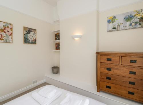 a bedroom with a dresser and paintings on the wall at 2 Church Street in Chipping Norton