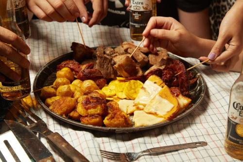 Glamping Itawa & Ecoparque turístico في فيلافيسينسيو: طبق من الطعام على طاولة مع الناس يأكلون