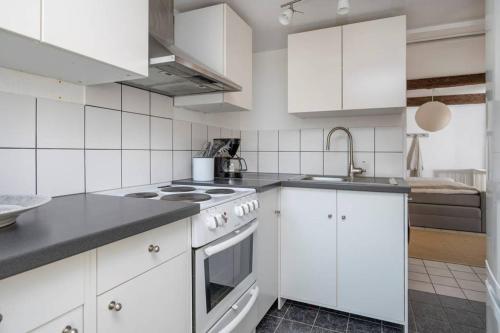 a white kitchen with white cabinets and a sink at Swedish Farmhouse near Malmö and Copenhagen in Trelleborg