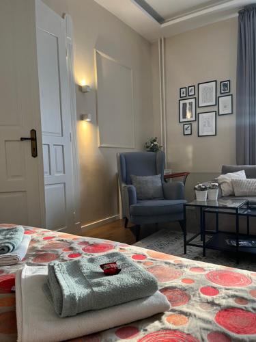 a bedroom with a bed and a chair and a table at Visit Debrecen Apartman in Debrecen