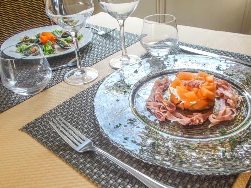 - une table avec une assiette de pâtes et des verres à vin dans l'établissement Hotel Inn Design Le Havre, à Montivilliers