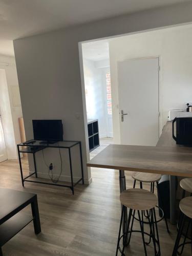 a dining room with a table and stools in a room at La mission in Saint-Martin-des-Noyers