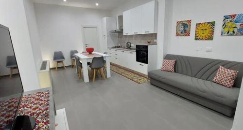 uma sala de estar com um sofá, uma mesa e uma cozinha em Casa vacanze Sicilia bedda partinico em Partinico