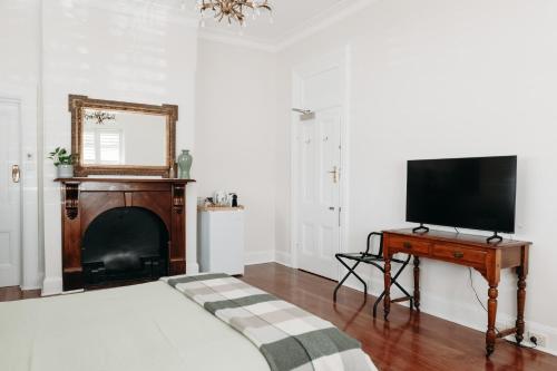 a bedroom with a bed with a television and a fireplace at The Westbury Dubbo in Dubbo