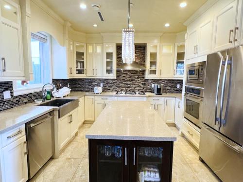 a kitchen with white cabinets and stainless steel appliances at Jennifer's House in Vancouver
