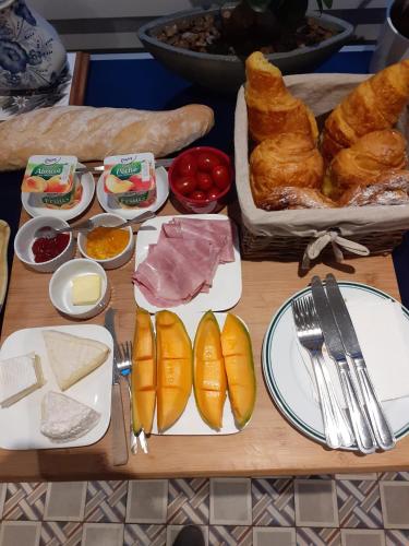 ein Tisch mit Brot und verschiedenen Arten von Lebensmitteln darauf in der Unterkunft Oasis Master Suite in Marconne