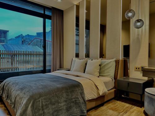 1 dormitorio con cama grande y ventana grande en HERE宅這兒私宅-屏市宅 en Pingtung City