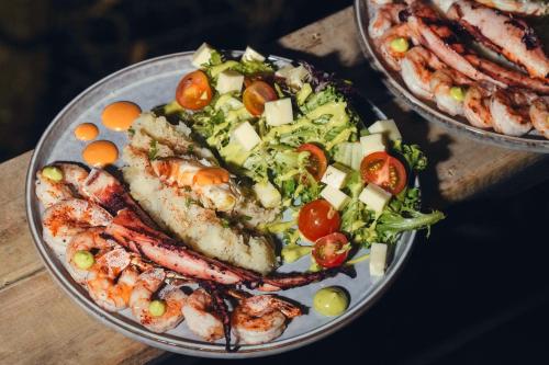 un plato de comida con camarones y ensalada en una mesa en Itawa Luxury Glamping & Ecoparque turísticos, en Villavicencio