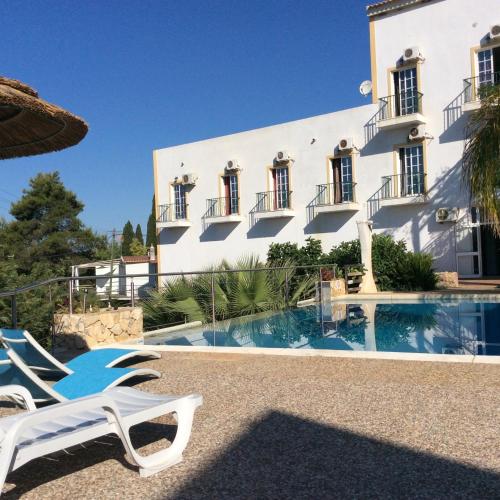 Un complejo con piscina y un edificio blanco. en Golda Sol, en Loulé