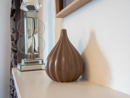 a vase sitting on a shelf next to a lamp at Pass the Keys Olive Tree Lovely Apartment with Sea Views in Grange Over Sands