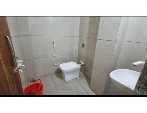 uma casa de banho com um WC branco e um lavatório. em Hotel Roopmati, Vidisha em Vidisha