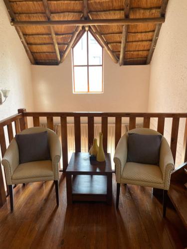 two chairs and a coffee table in a living room at Alendo Apartments in Johannesburg