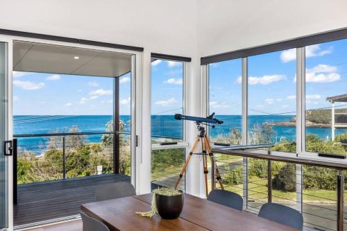 a room with a table and a view of the ocean at Shelly's Waterfront Property - Brand New in Kioloa
