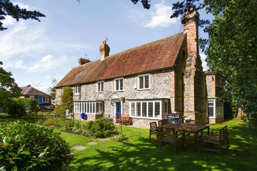 an old stone house with a table in the yard at Walnut Tree House in Rustington