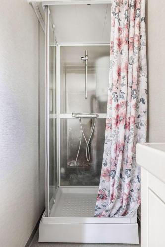 a shower with a shower curtain in a bathroom at Gulliga torpet in Vislanda