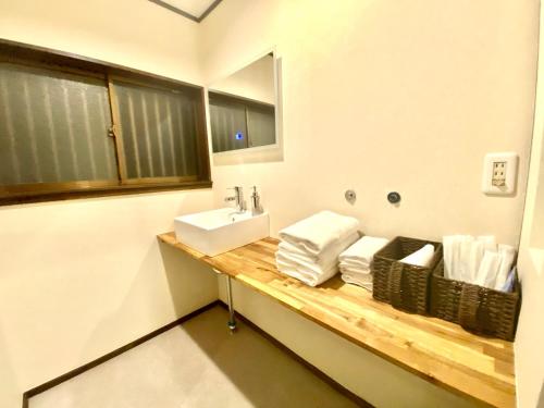 a bathroom with a sink and a counter with towels at 外宮前別邸　星織 in Funaechō