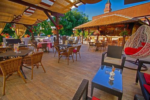 un patio al aire libre con mesas, sillas y mesa de comedor en Hotel Petrus en Paraćin