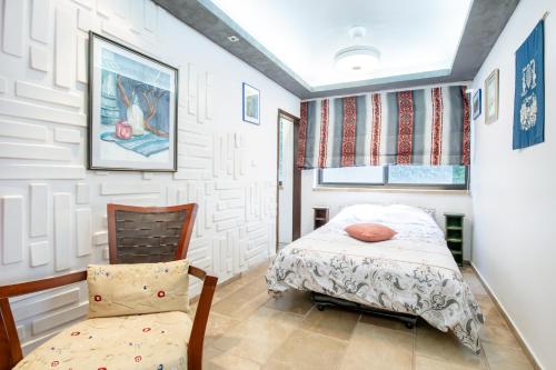 a bedroom with a bed and a chair at הים פוגש את ההר- בית בלב הגליל Sea & Mount in Adamit