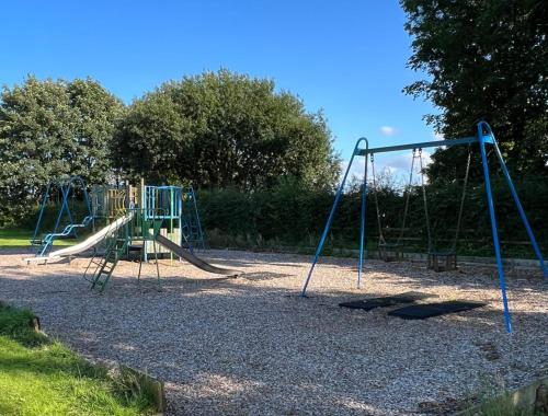 an empty playground with a slide in a park at Pass the Keys Spectacular 7BR House Hot Tub and Gardens in Gretna in Gretna Green
