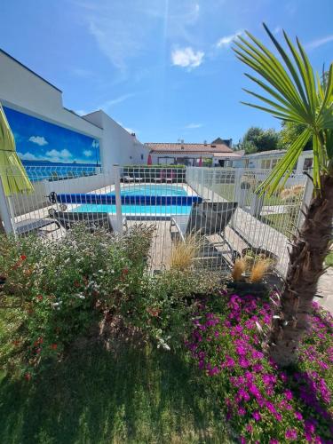 a garden with purple flowers and a swimming pool at Appart Madame à Chatelaillon plage 2 pers in Châtelaillon-Plage