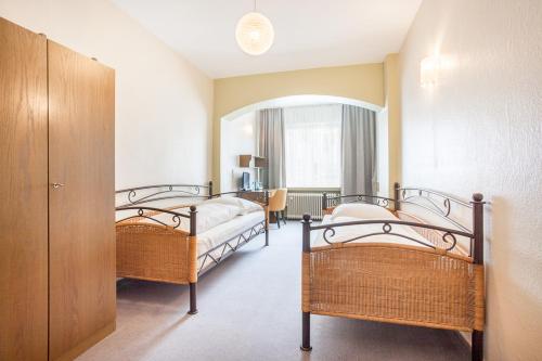 a bedroom with two beds and a table in a room at Hotel Union by TM in Dortmund