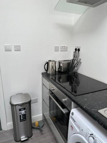 a kitchen with a counter with a stove top oven at New Cozy Studio Apt. House with Parking. Entire space in Slades Green