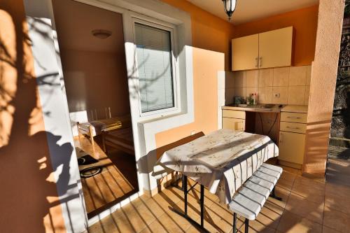 a small kitchen with a table and a window at Apartments Vitic in Sutomore