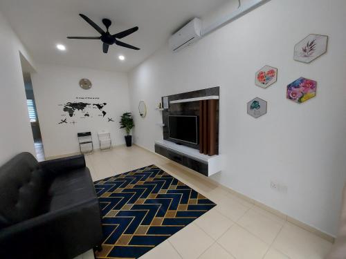 uma sala de estar com um sofá e uma ventoinha de tecto em M2H Homestay em Kuantan