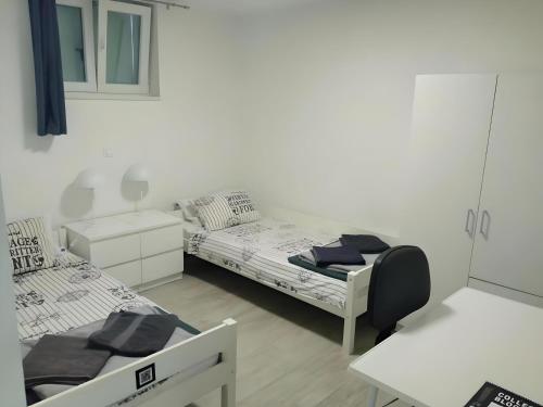 a white room with two beds and a desk at Apartment Patrik in Vabriga