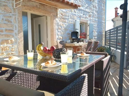een glazen tafel op een balkon met eten erop bij Apartment Patrik in Vabriga