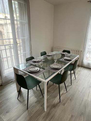a dining room table with chairs and a glass table top at Vivez au coeur Historique - St François - Grand appartement confortable in Le Havre