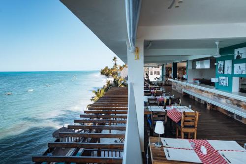 a restaurant on the beach with tables and the ocean at Pili Pili Sunrise in Jambiani