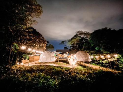 比亞維森西奧的住宿－Glamping Itawa & Ecoparque turístico，一群帐篷在晚上在田野里