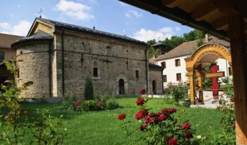 ein großes Steingebäude mit einem Hof mit Blumen in der Unterkunft Bagins Apartman in Kostolac