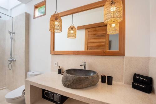 La salle de bains est pourvue d'un lavabo en pierre et d'un miroir. dans l'établissement Tamary's Villa 3 BR in Ungasan, à Ungasan