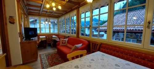 a living room with a red chair and a window at Garnì Stella Alpina in Canazei