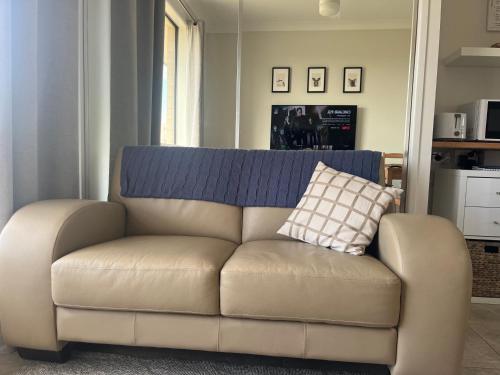 a brown couch with a pillow on top of it at Freyjas Guest Suite in Curra