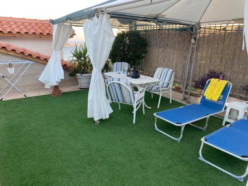 a patio with a table and chairs under a tent at Siga Siga Apartment in Megara