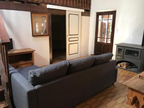 uma sala de estar com um sofá e um fogão em Gîte en pierre au cœur des chiens de traîneau em Mirmande